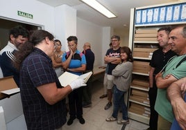 El archivero municipal muestra documentos durante una visita.