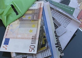 Recortes de periódico tapados por billetes como los utilizados para el timo del tocomocho.