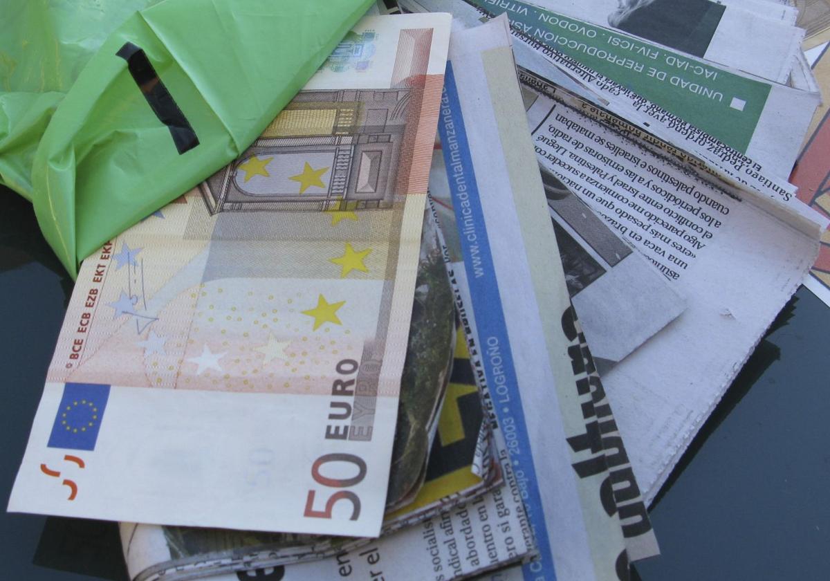 Recortes de periódico tapados por billetes como los utilizados para el timo del tocomocho.