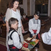 Dos niños vestidos con indumentaria tradicional, durante la ofrenda de frutos.