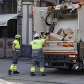 Trabajadores de Palencia Deslumbra recogen basuras de los comercios de la Calle Mayor.