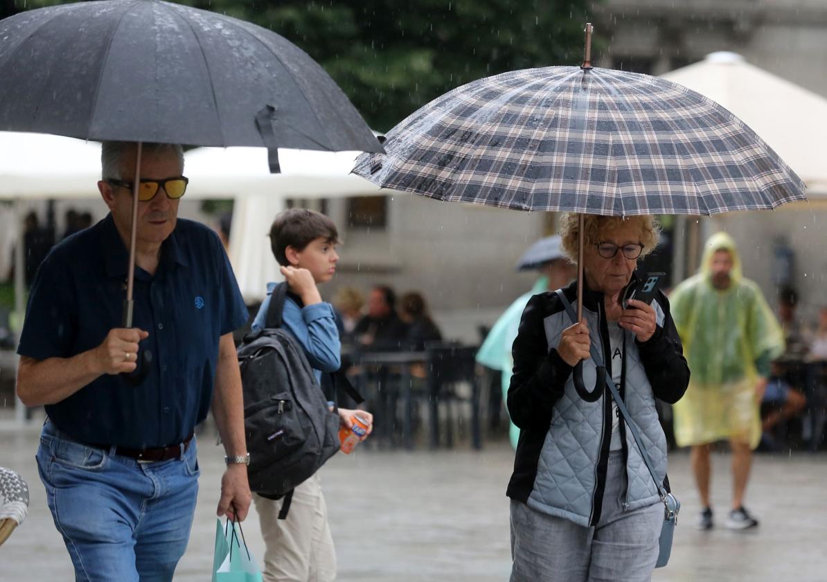 Viandantes se protegen de la lluvia en Segovia, hace unos días.