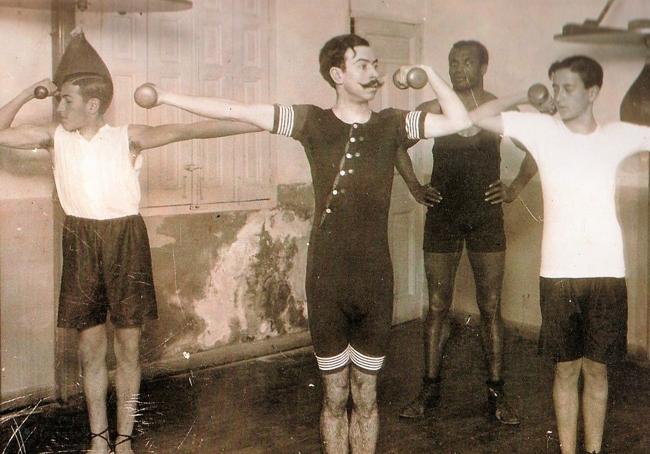 Un grupo de hombres, en un gimnasio, a finales del siglo XIX.
