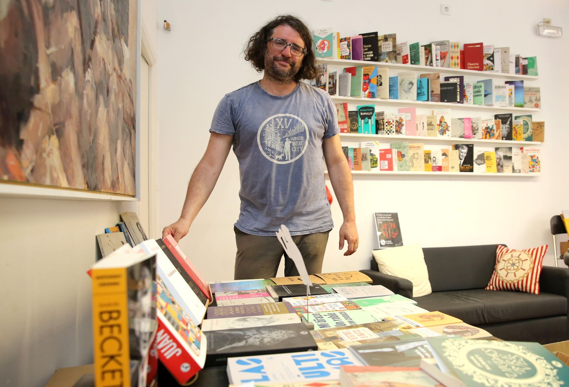 Carlos Rod, en la editorial La Uña Rota, junto a mucho de los títulos publicados.