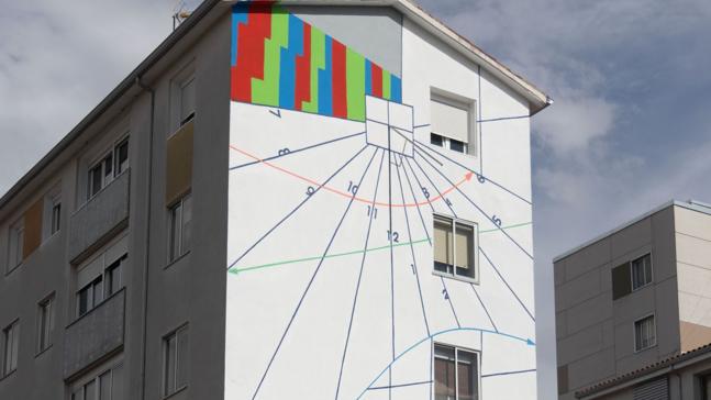 ¿En qué calle del barrio de La Rondilla hay un reloj solar gigante sobre una fachada creado por el muralista Demsky?