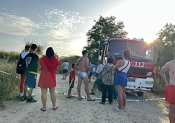 Bañistas en la zona donde se busca al joven desaparecido en Alba de Tormes junto a un campeón de bomberos de la Diputación de Salamanca.