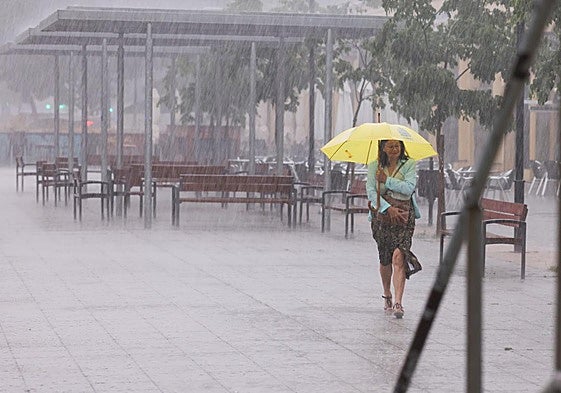 Una mujer se protege de la tormenta en Valladolid, en una imagen de archivo.