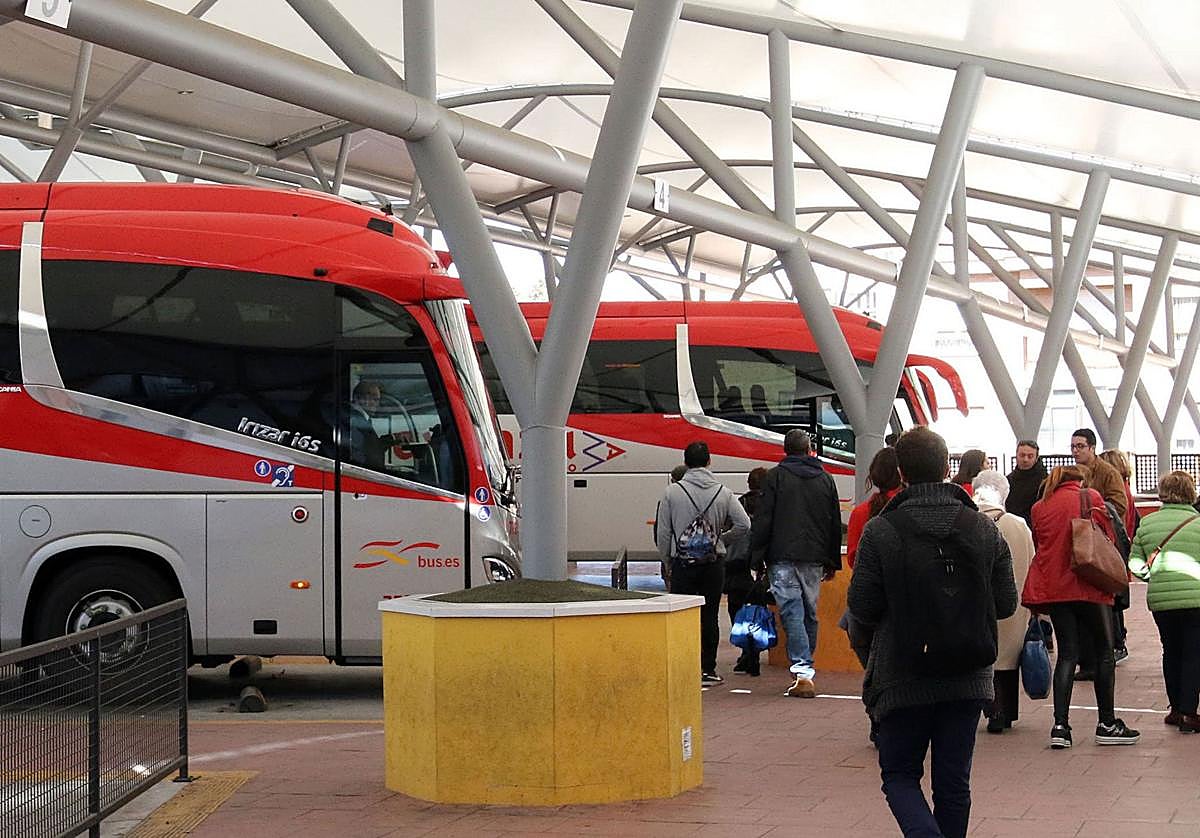 Varias personas esperan su turno para subir a un autobús.