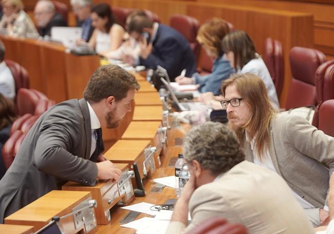 Miguel Suárez (Vox) habla con Pablo Fernández (Unidas Podemos) en el hemiciclo, durante el Pleno.