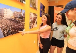 Tres chicas comentan una de las fotografías de la exposición.