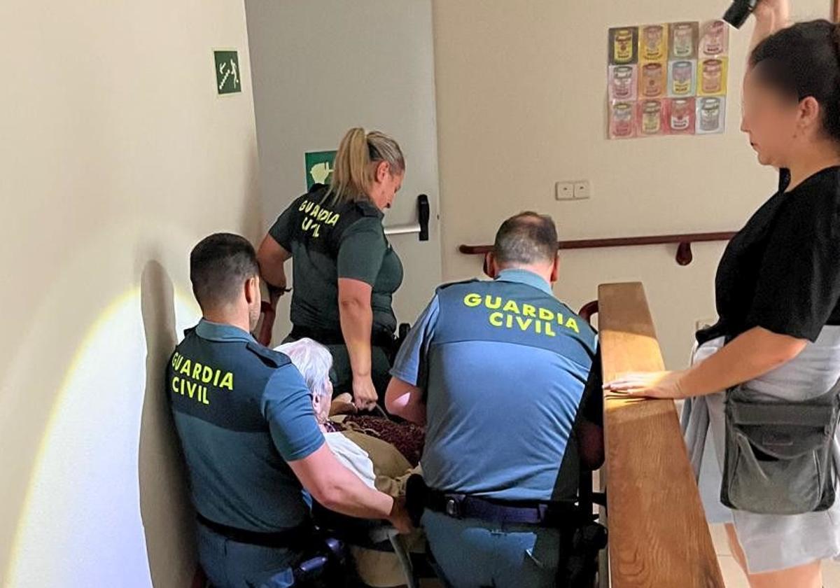 Momento en que los agentes ayudan a una mujer en silla de ruedas.