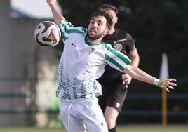 Un jugador del Betis trata de controlar un balón.