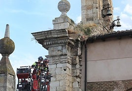 Los bomberos comprueban el estado de la espadaña, tras el desprendimiento.