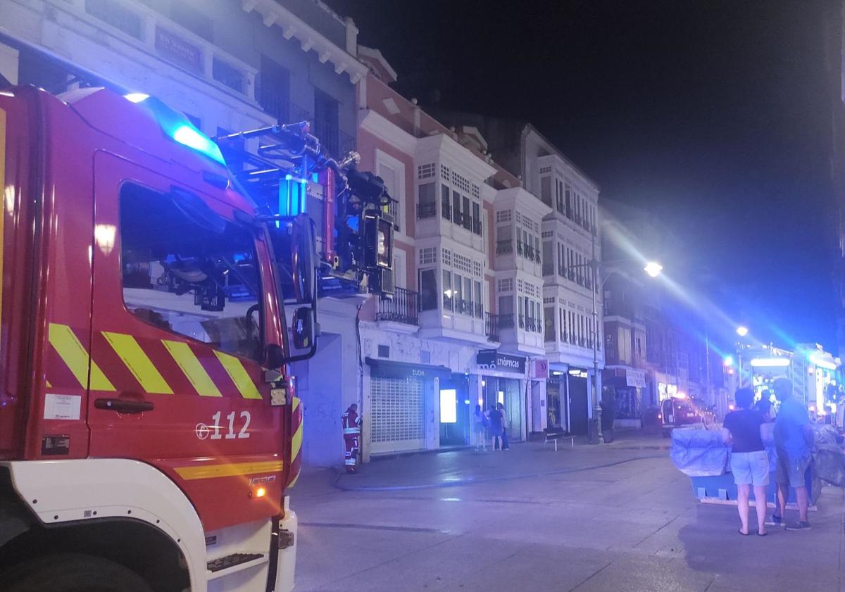 Imagen principal - Los bomberos apagan el incendio en el local de la Calle Mayor.