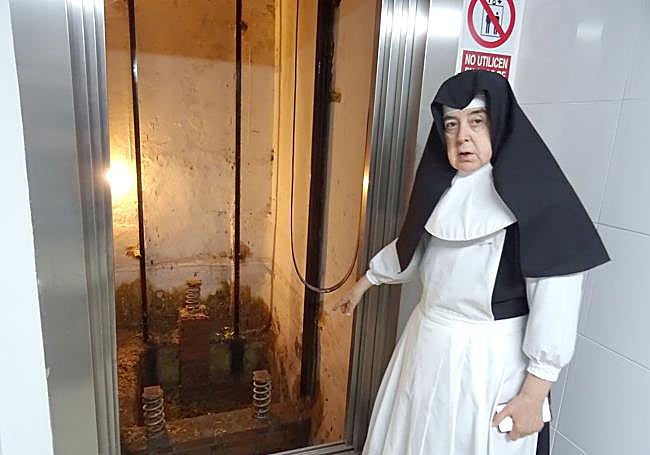 Sor María Bravo, directora de la residencia San José, muestra el foso del ascensor averiado por el aguacero.