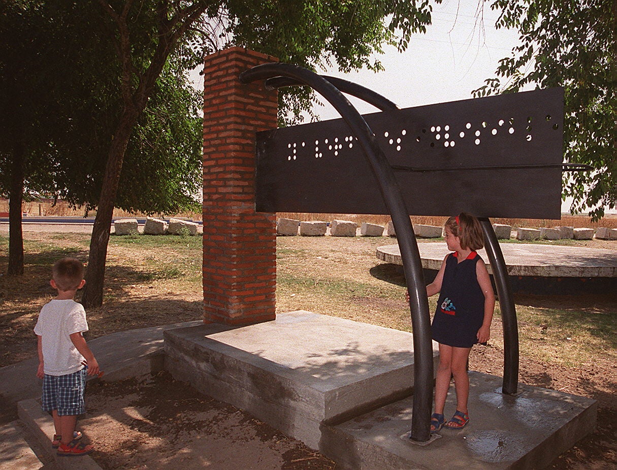 Dos niños juegan junto al nuevo trabajo de Ricardo Díaz, llamado La verdad es invisible. 17 de agosto de 2000.