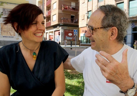 Elia García e Ignacio Sanz conversan y sonríen sentados en un parque de Segovia.