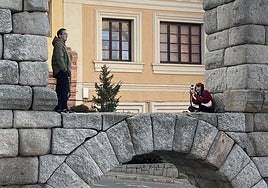 Una pareja de turistas se hace una fotografía subidos en el Acueducto de Segovia.