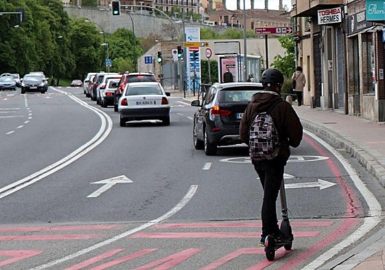Una persona circula en patinete eléctrico por una calle de la ciudad de Segovia.