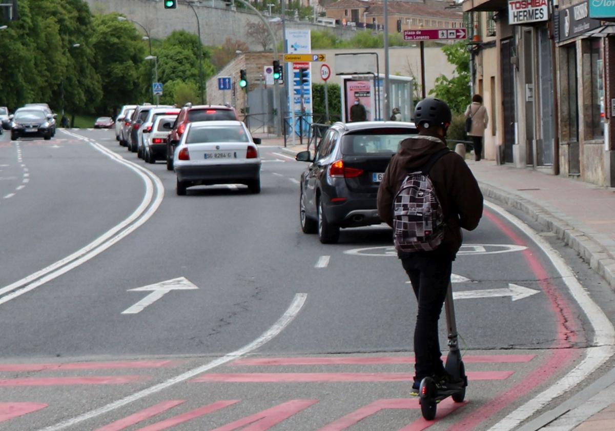 Una persona circula en patinete eléctrico por una calle de la ciudad de Segovia.