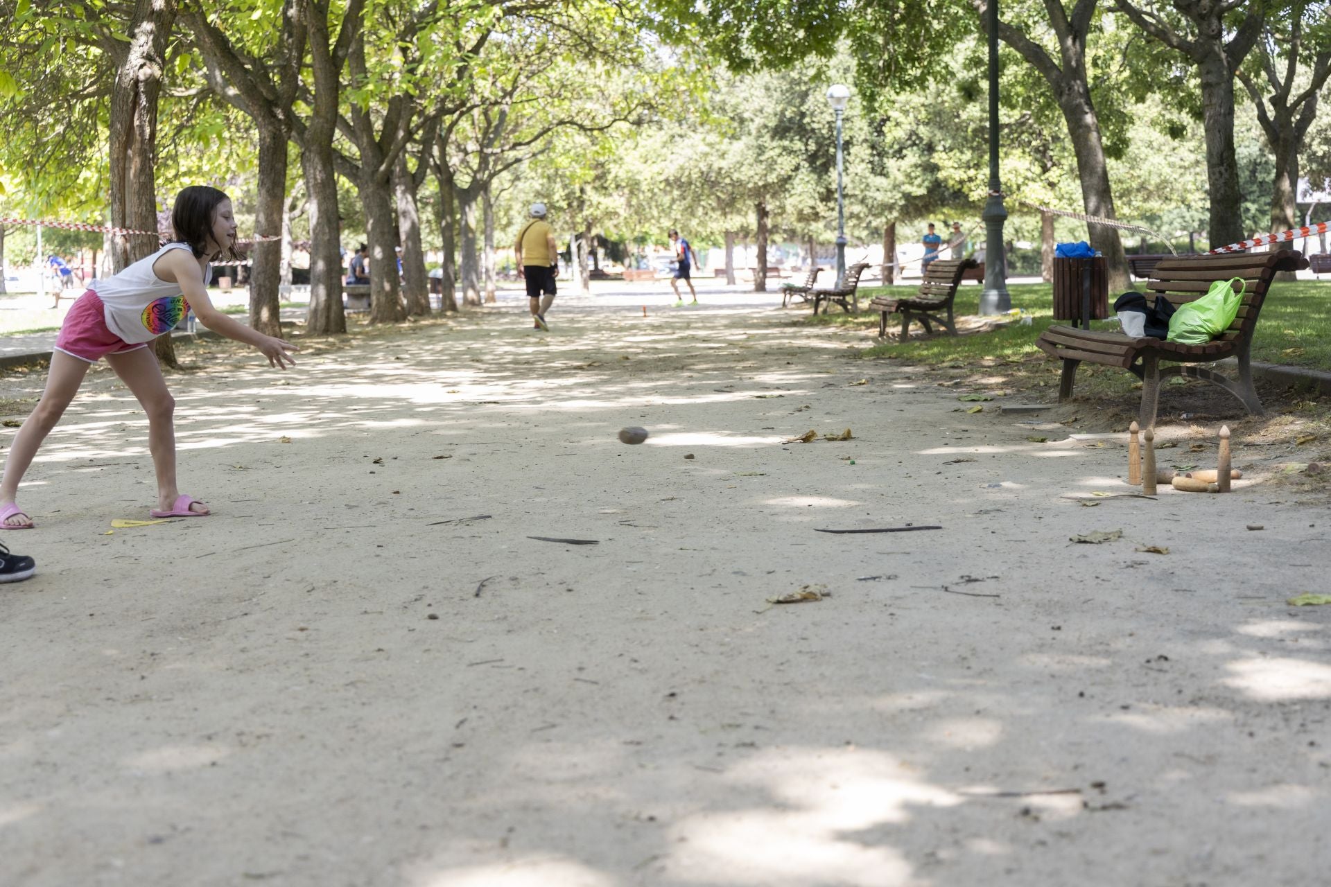 Una niña jugando al juego tradicional de los bolos. 