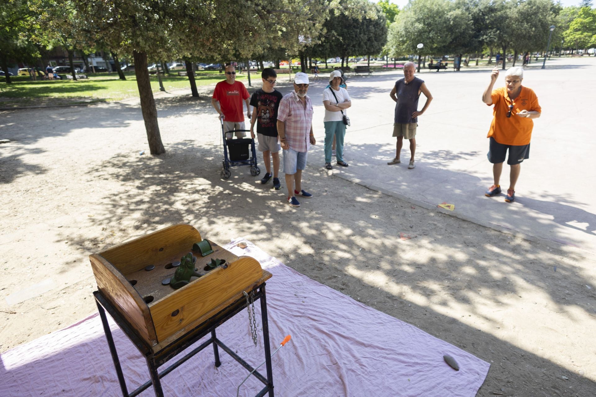Varios vecinos mirando el juego de la rana.