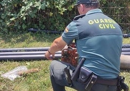 Un agente de la Guardia Civil junto al proyectil localizado en Cabria.