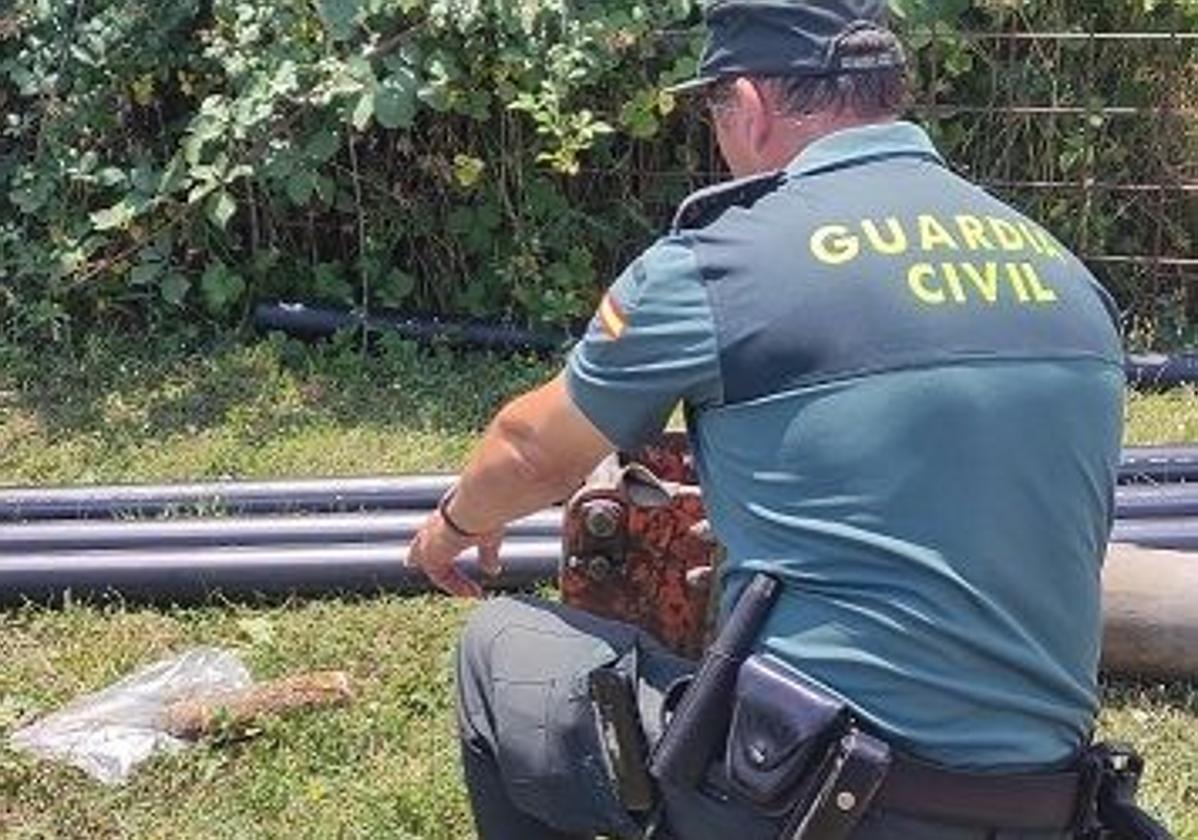 Un agente de la Guardia Civil junto al proyectil localizado en Cabria.