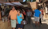 Multitud de personas participan en un evento celebrado en un pueblo de Segoia en época estival.