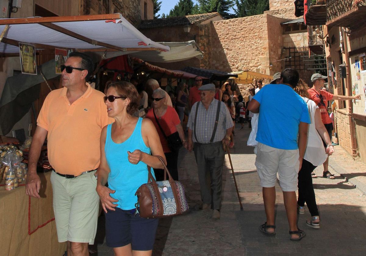 Multitud de personas participan en un evento celebrado en un pueblo de Segovia en época estival.