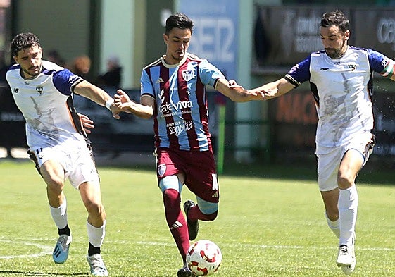 Javi Borrego conduce el balón ante dos defensores del Barakaldo.