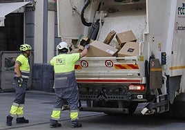 Operarios de Palencia Deslumbra recogen basura en la Calle Mayor.
