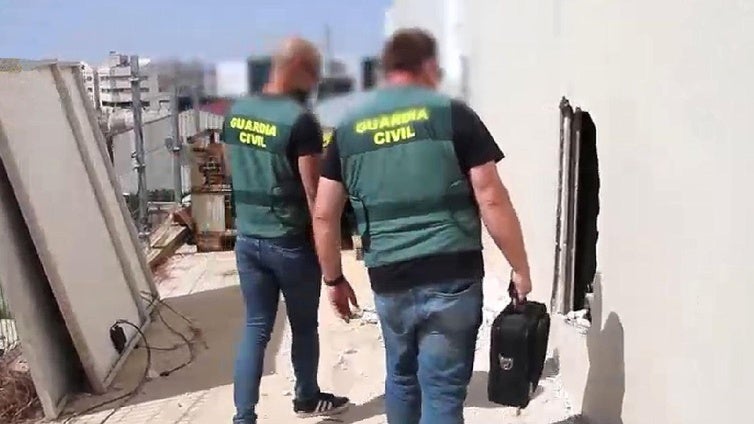 Dos agentes examinan uno de los butrones abiertos por los ladrones de cobre.