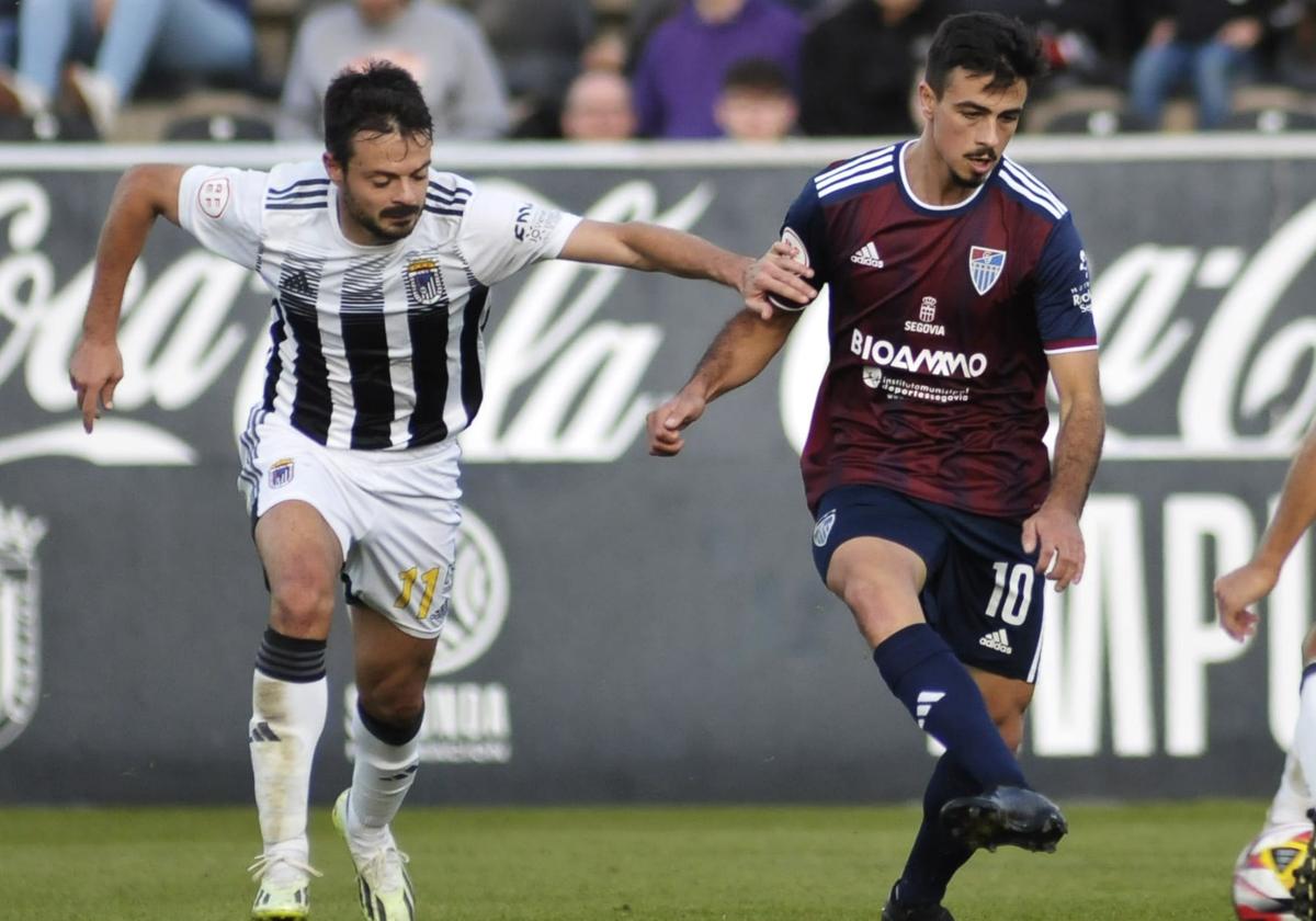 Samu Manchón persigue a Javi Borrego en un partido entre el Badajoz y la Gimnástica Segoviana.