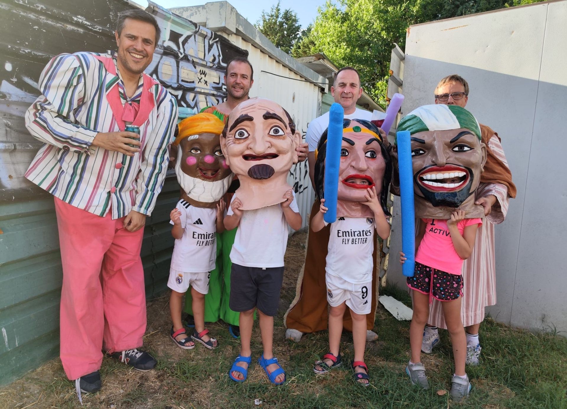 Los niños cogen las caras de los cabezudos.