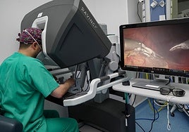 Un cirujano opera median el manejo del robot quirúrgico Da Vinci.