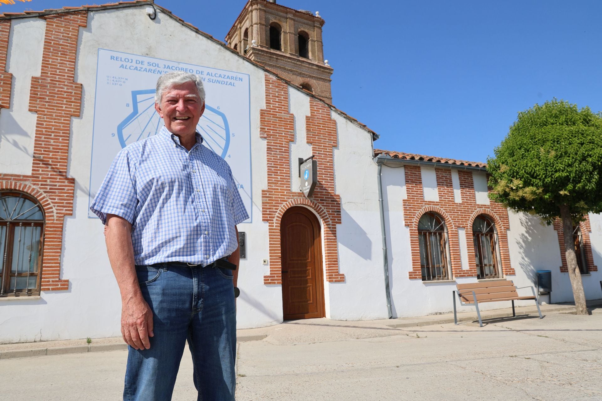 El físico Luis Vadillo Sacristán, junto a la fachada del Ayuntamiento de Alcazarén, donde luce uno de los relojes solares elaborados por él.
