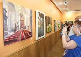 El público contempla la exposición y fotografía los cuadros.