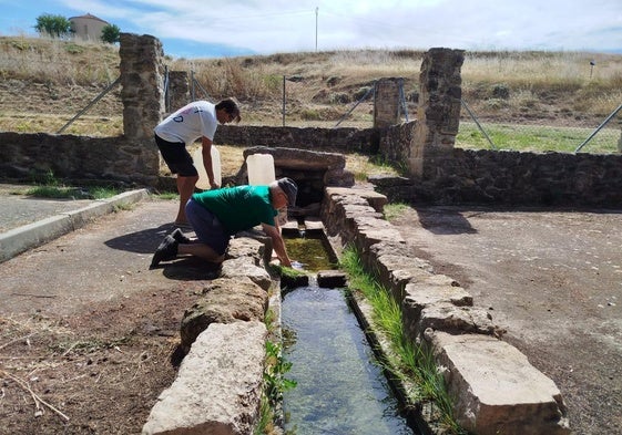 Vecinos de Vellosillo acuden a por agua a una fuente.