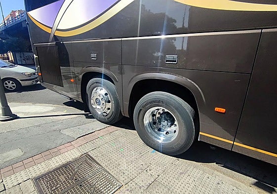 Las ruedas traseras del bus se suben a la acera, donde se ven pintadas las marcas por las que se guiará el recorte.