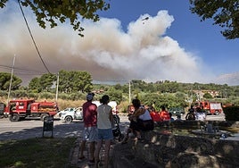 Vecinos observan este martes por la mañana desde Mombeltrán la evolución del incendio.