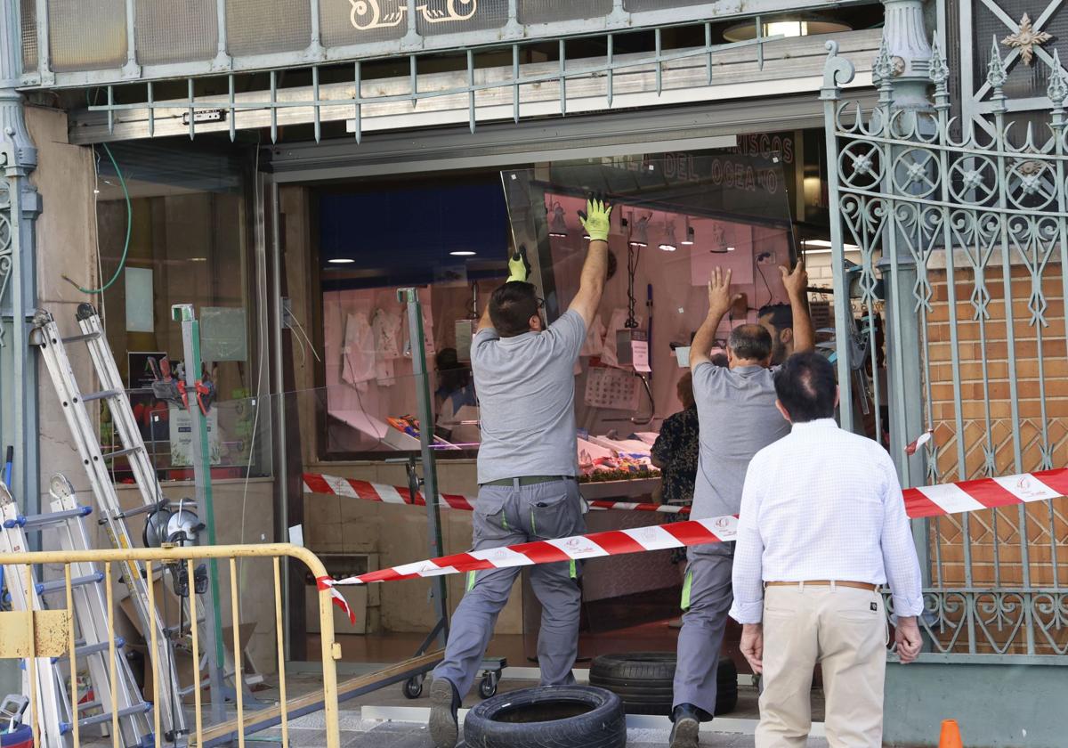 Los operarios colocan las nuevas puertas, en el acceso a la plaza desde la calle Joaquín Costa.