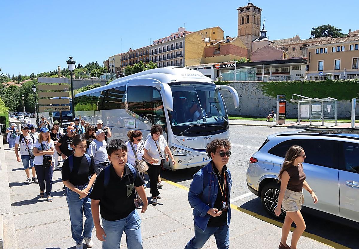 Grupo de turistas que se acaban de bajar de un autobús en Vía Roma, en Segovia.