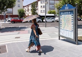 Una mujer se protege del sol con un paraguas en el centro de Valladolid.
