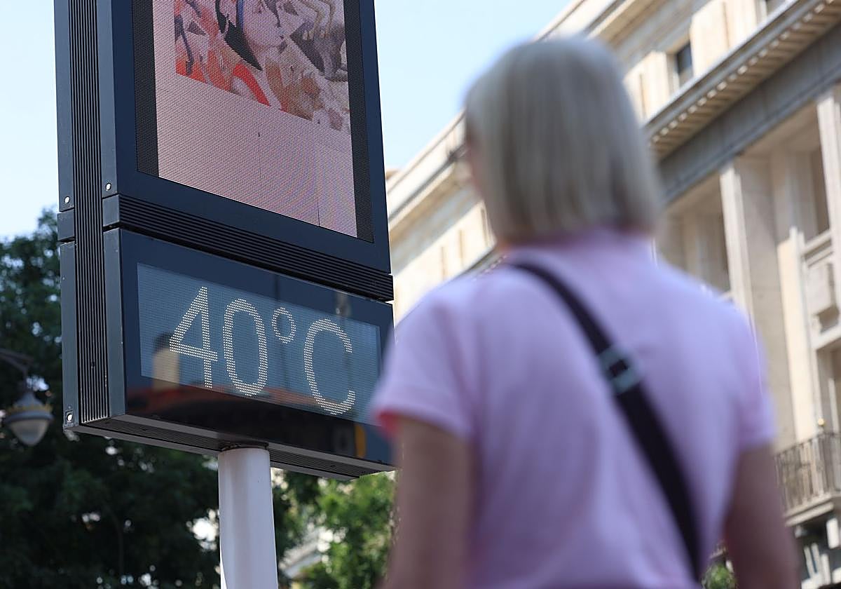 Una mujer pasa por delante de un termómetro que marca 40 grados, este lunes en Valladolid.