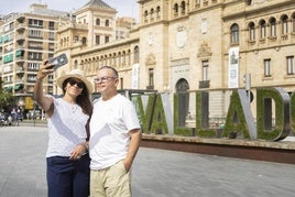 Turistas se toman un selfie junto al letrero que reza 'VALLADOLID' en la Acera de Recoletos.