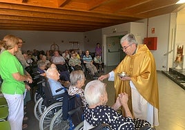El arzobispo da la comunión a varios residentes durante la misa del cincuentenario