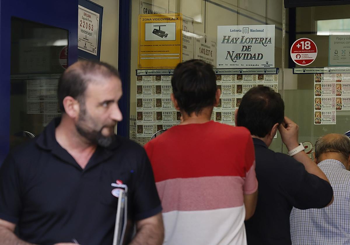 Varios clientes guardan cola en una administración.