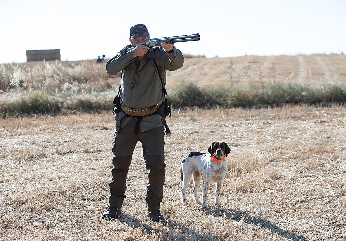 Un cazador, con su perro y su escopeta.