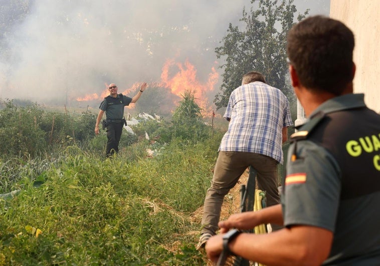 Agentes de la Guardia Civil y un vecino presencian el fuego del incendio de Congosta.